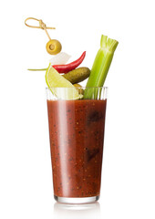 Glass of bloody mary cocktail mix with black pepper and celery on white background with pickle and olive.