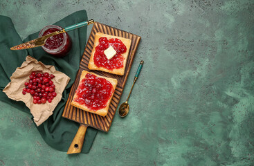Wooden board of tasty toasts with cranberry jam on green grunge background
