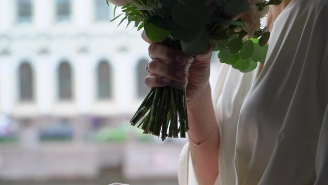 Female in dress hold in hands bouquet with ribbons oof white and pink rose peony flowers. Gift for a woman, holiday, wedding bouquet of the bride. Floristics.