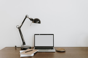 Home office desk workspace with laptop computer, lamp on desktop table. Modern interior design concept