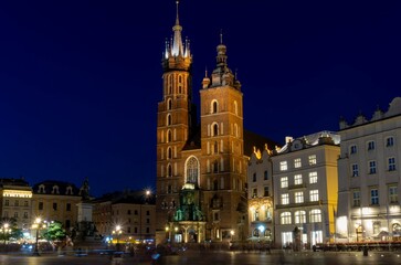 Fototapeta na wymiar Krakow main square church at night with people in ghost effect