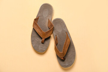 Brown flip-flops on beige background