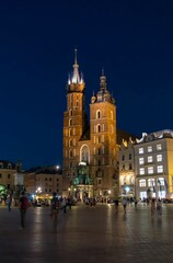 Fototapeta na wymiar Krakow main square church at night with people in ghost effect