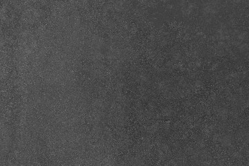 Abstract dark black grunge background with gritty texture.