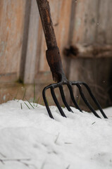 Close-up of an old pitchfork with a wooden handle, an agricultural tool. 