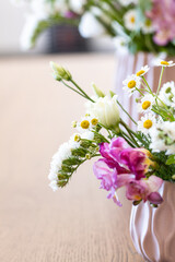 Two modern design vases with flowers like daisies and freesias in spring. Countryside spring flowers, nature and floral beauty..Spring time, colorful greenery and change of season