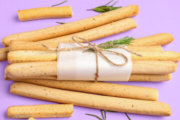 Tasty Italian Grissini on lilac  background, closeup