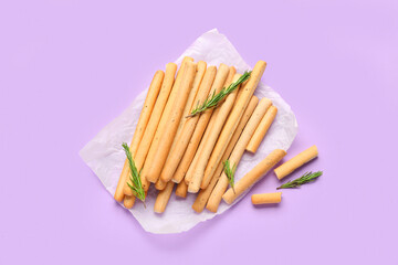 Tasty Italian Grissini on lilac  background