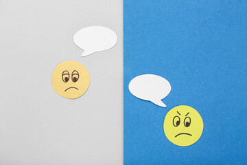 Paper faces with speech bubbles on color background. Dialogue concept