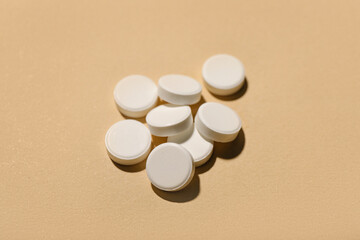 White pills on beige background