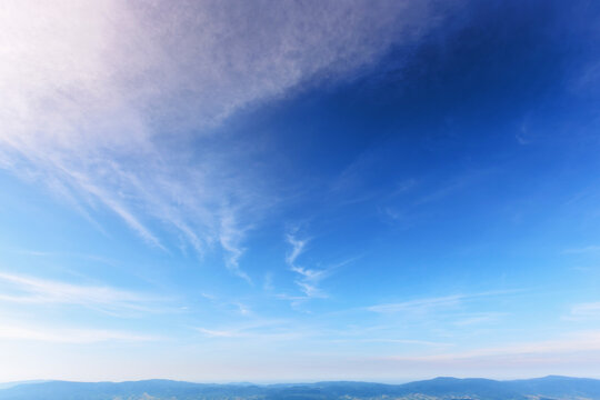 sunny weather forecast background. blue sky with white clouds above horizon in morning light