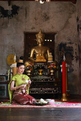 Beautiful Asia woman with Thai Traditional dress prepare lotus flower for make merit on Buddhist holy day
