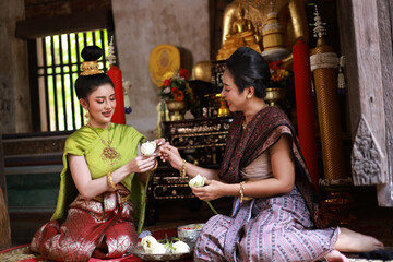 Beautiful Asia woman with Thai Traditional dress prepare lotus flower for make merit on Buddhist holy day