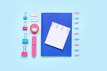 Composition with sticky note and stationery on blue background