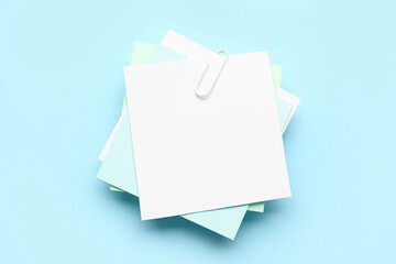 Sticky notes with paper clip on blue background