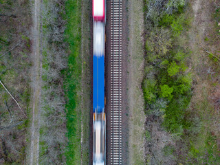 aerial top down view of a train in motion on the train tracks going through the countryside