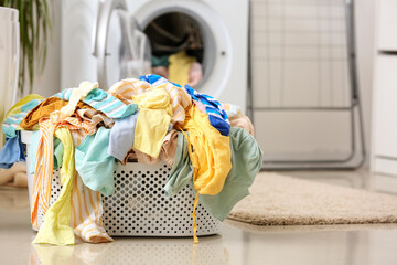 Basket with dirty clothes on floor in laundry room