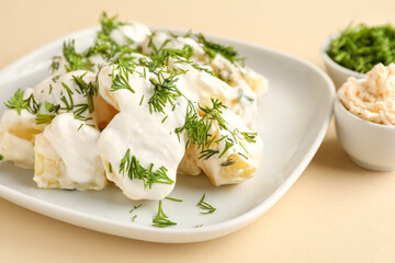 Plate of tasty Potato Salad with greens on yellow background, closeup