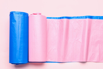 Different rolls of garbage bags on pink background