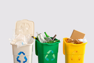 Containers with different types of garbage on light background. Recycling concept