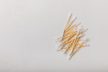 Cotton swabs on a white cement background. Bamboo cotton buds. Means for hygiene of ears. Eco-friendly materials.Hygienic cotton ear buds.