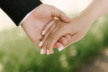 A guy and a girl holding hands on a natural background
