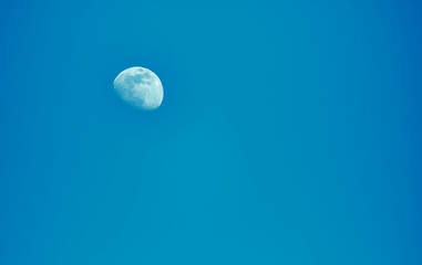 White moon against blue sky.