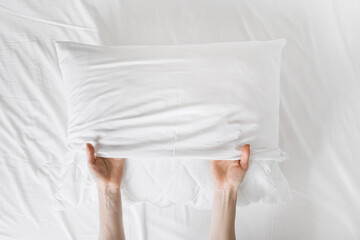 woman changing white cotton cover on pillow