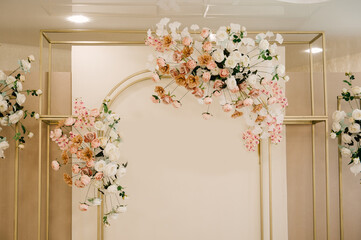 The large bright hall is decorated with flowers for the event, the wedding decor of the presidium table of the newlyweds