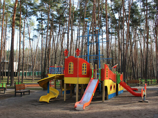 Empty open air colored play park with straight and spiral slides for children