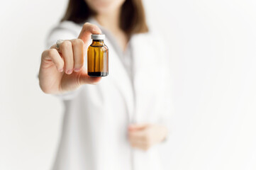 medicine bottle close-up in the doctor's hand. medical treatment concept. the doctor extends the medicine