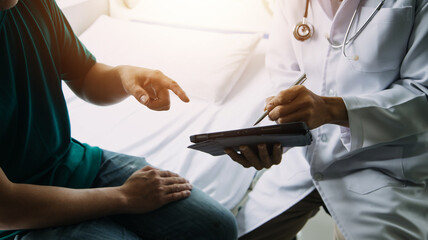 A health visitor with tablet explaining a senior woman how to take pills.