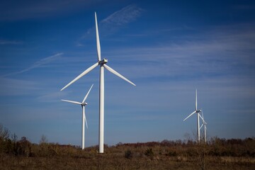 Wind turbines against blue sky background.