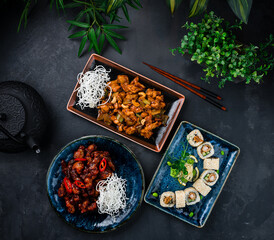 Asian cuisine set of chicken with onion, celery, cashew nuts, pork in Thai sweet chili sauce and sushi roll set with shrimps tempura, cucumber, onion.