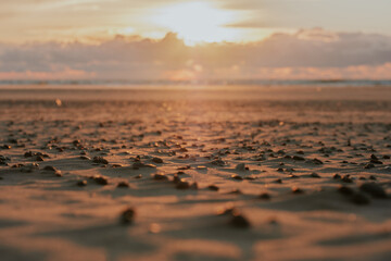 Sunset in the sea with unmelted ice floes that look like little caps. Clouds like a mountain range above the horizon and a blurred sun in the background. Copy space. Background for quotes.