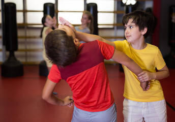 Two boys in sparring practice self defense technique in the gym