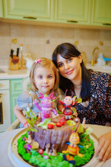 mother and daughter with a large cake with figures of fairy-tale characters