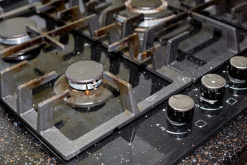 Gas stove with dirty glass-ceramic surface. Cooking stove care