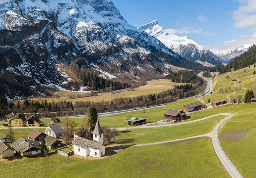 Areal image of the idyllic Alps village of Medels im Rheinwald with the reformed church Medels and the Alps peak Einshorn at the background, Grisons, Switzerland