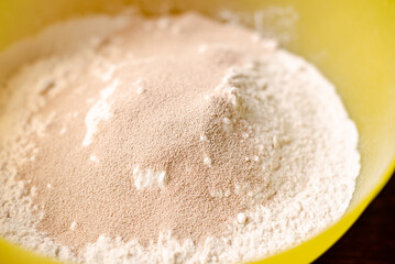 Flour and dry yeast. Preparation for preparation of dough for bread or pizza. Stirring fast-acting granillated yeast with sifted flour.