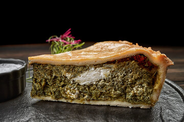 Savory kish pie slice with fresh herbs and cheese, close-up