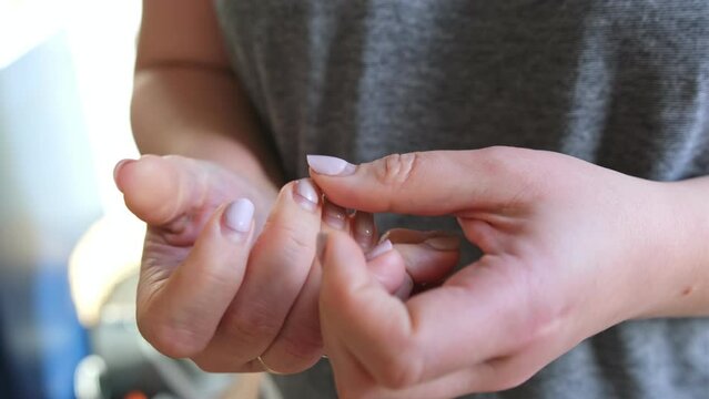 Caucasian Woman Examining and Scratching Outgrown Hybrid Nails