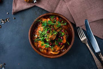 Canned stewed meat with vegetables, potatoes, tomatoes, onions, peppers, carrots, pomegranate seeds and herbs.
