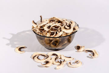 Dried mushrooms champignons in a transparent bowl isolated on a white background. Used in world cuisine. 