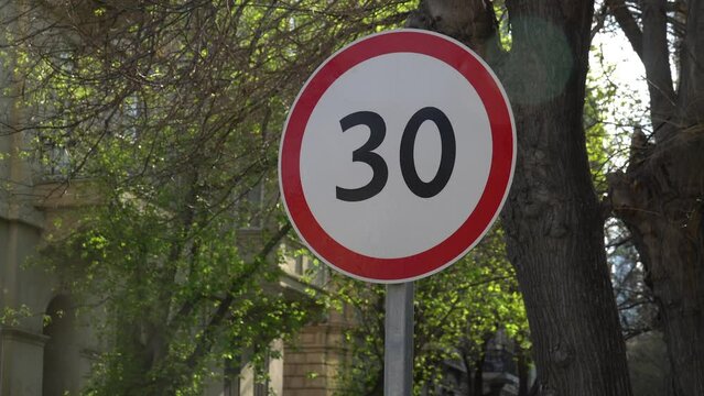 Red road sign with a speed of only 30 inside a white sign