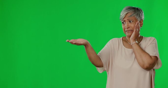 Elderly woman, open hand and space by green screen with fear, scared face and worry by background. Senior female, palm and mockup with stress, product placement and thinking with anxiety by backdrop