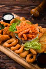 Appetizer fried chicken legs, crispy onion rings, croquettes, carrots, sauces and greens.