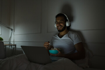 Handsome man enjoying a movie late at night