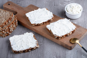 Rye bread with cream cheese on grey table