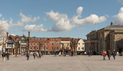 Salisbury, Wiltshire, England, UK. 2023. People walk on Market Place in the city centre surrounded with historic buildings, The Guildhall, shops and offices.